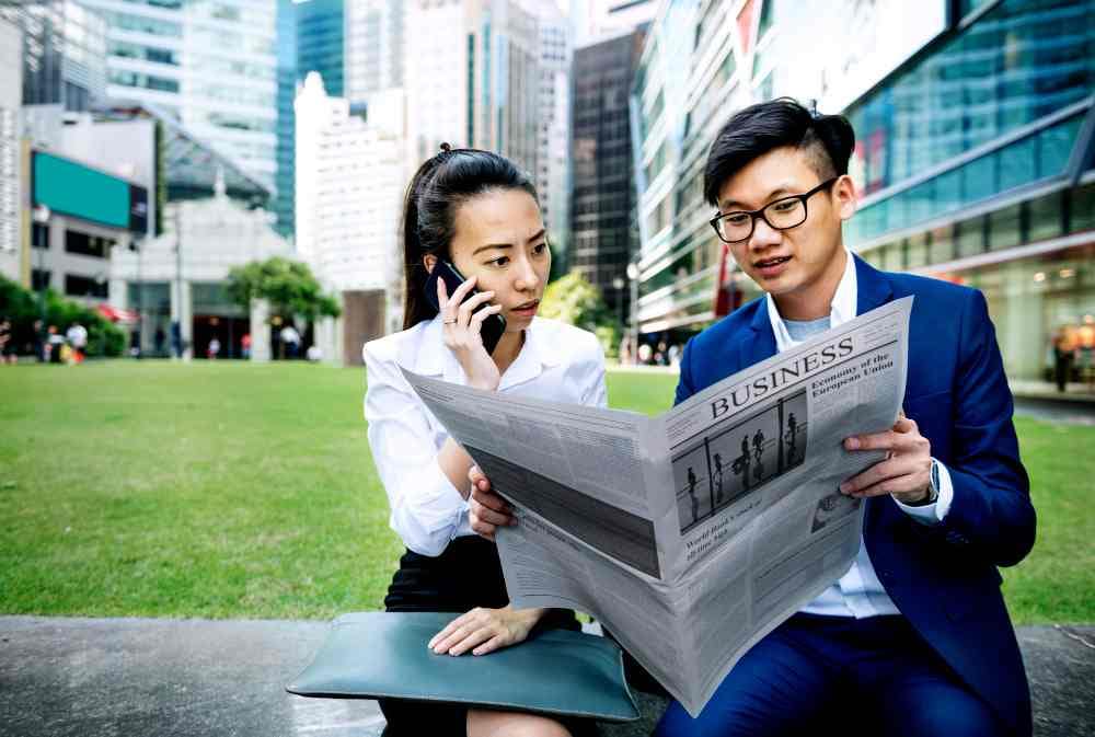 Two person reading a press release in a news paper. (illustration)